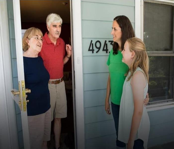 A mother and daughter talking to male and female neighbors
