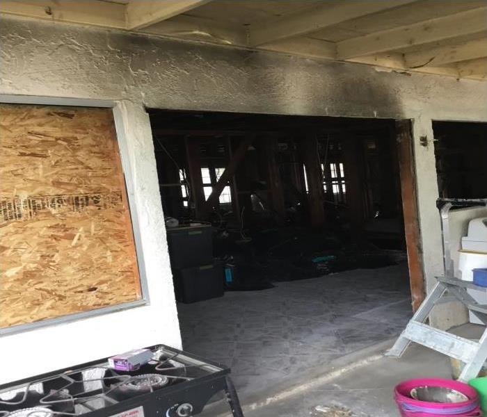 soot on white walls with window covered with plywood