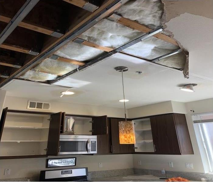 brown kitchen cabinets, exposed ceiling with insulation and beams visible