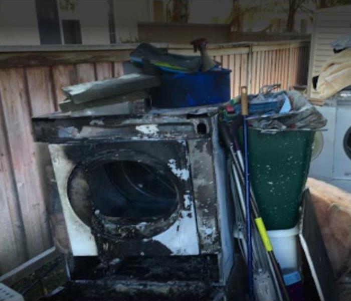 white dryer with black soot and melted door