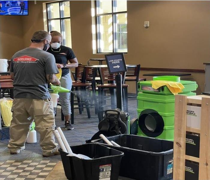 Servpro crew inside restaurant cleaning smoke and soot 