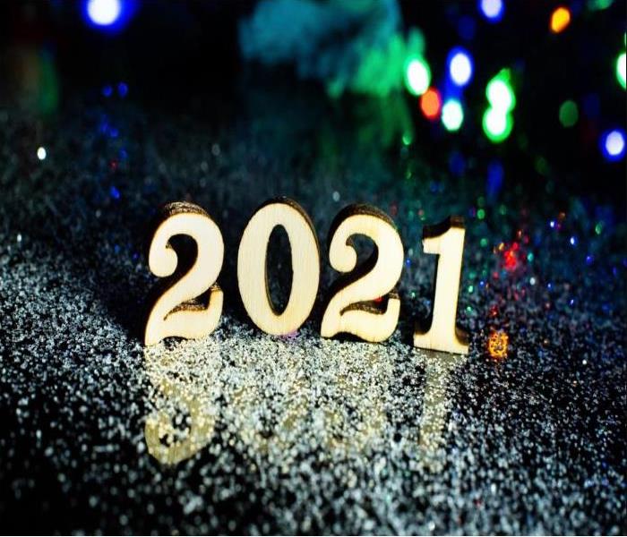 the numbers 2021 in gold with green, blue red blurred lights in background,